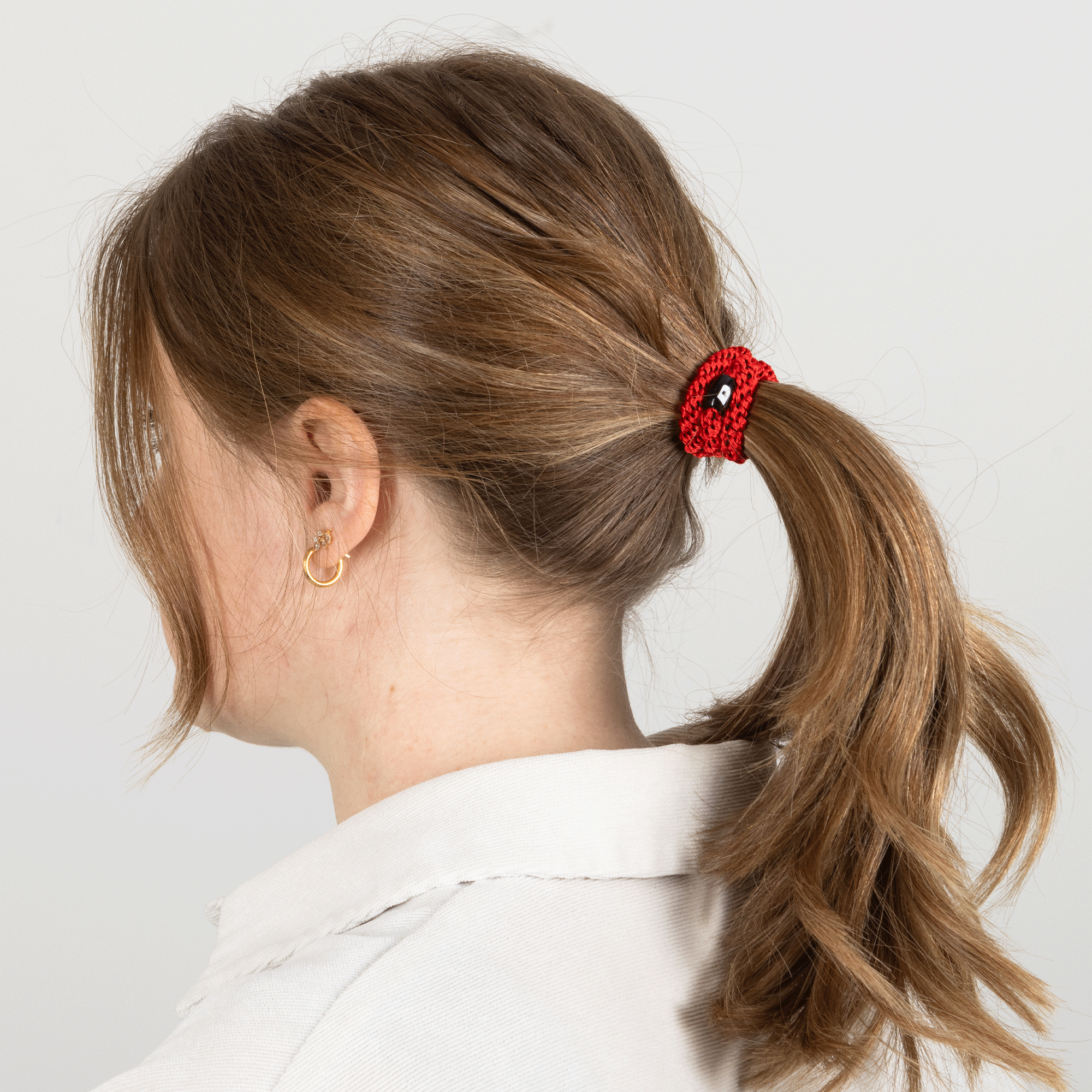 red hair tie with dynapac logo in hair