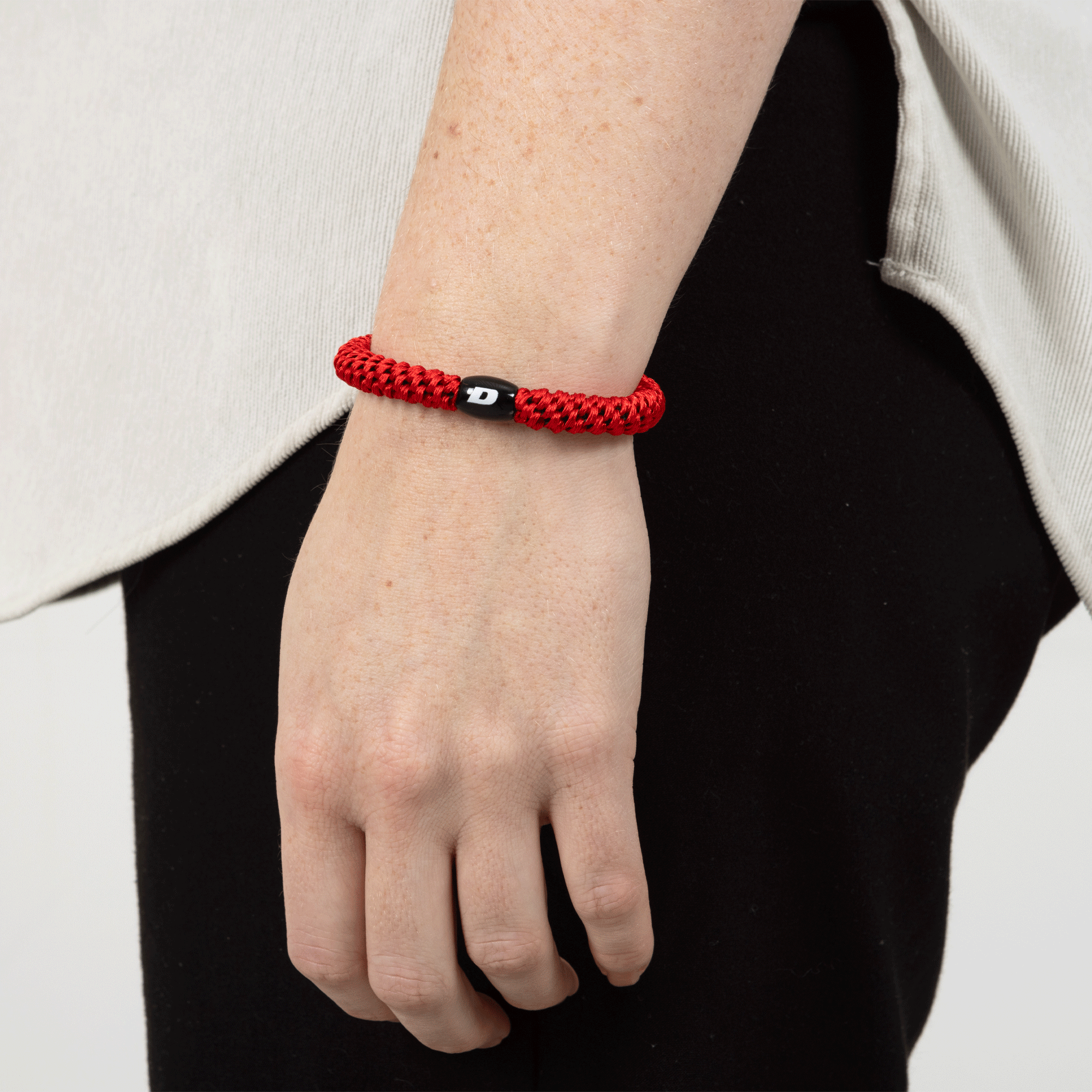 red hair tie with dynapac logo on arm